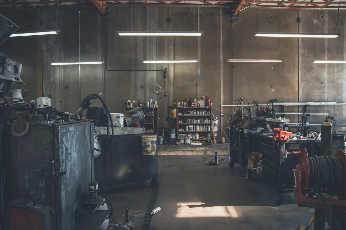Dim workshop interior with cable spools and equipment along the wall